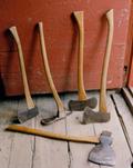 Meubles et outils de la chalouperie Godbout. Différentes sortes de haches étaient utilisées par le chaloupier au moment de la préparation des parties structurales de l'embarcation