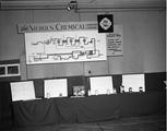 Complexe industriel de l'île aux Chats. Table de présentation des produits de la Nichols Chemical Company lors d'une exposition, Salaberry-de-Valleyfield (1959).