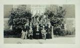 Groupe de jeunes gens (filles et garçons) sur les marches d'une école; au premier rang : trois Frères de l'Instruction chrétienne et une religieuse des Soeurs Grises de la Croix. Vers 1941