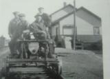 Ancienne gare de Saint-Henri. Photographie de travailleurs sur une draisine avec l'ancienne gare de Saint-Henri en arrière-plan.