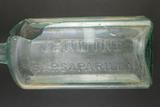 Bouteille à médicament. Détail de l'inscription sur la face avant